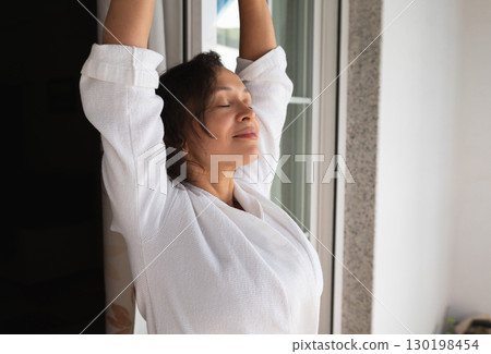 Relaxed Woman Stretching Near a Window in Natural Daylight Relaxed Woman Stretching Near a Window in Natural Daylight 130198454