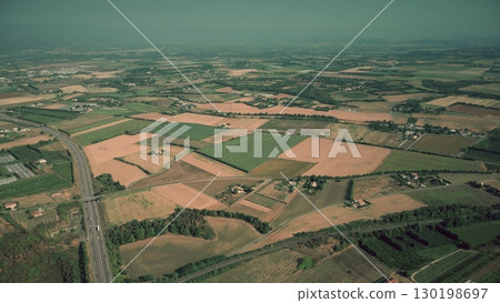 Aerial view of agricultural landscape with fields, farms, and a highway near Valence in southern France. Wide aerial panorama of cultivated farmland and rural countryside Aerial view of agricultural landscape with fields, farms, and a highway near Valence in southern France. Wide aerial panorama of cultivated farmland and rural countryside 130198697