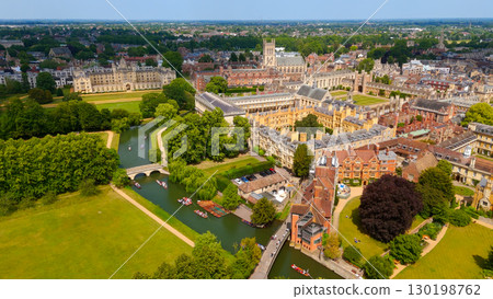 Punting on the River Cam flowing through Cambridge University on a sunny summer day 130198762