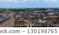 Cambridge cityscape featuring rooftops, Cambridge University and green spaces under a cloudy sky 130198765