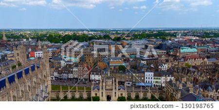 Cambridge cityscape featuring rooftops, Cambridge University and green spaces under a cloudy sky 130198765