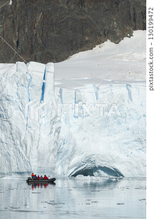 Tourists observing a glacier on the Antarctica, Paradise bay, Antartic Peninsula. 130199472