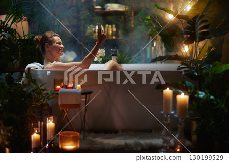 Modern Relaxation: Woman with Phone in Bubble Bath Modern Relaxation: Woman with Phone in Bubble Bath 130199529