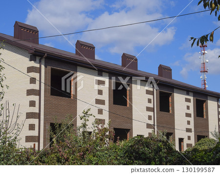 An apartment building under construction with a metal corrugated roof. An apartment building under construction with a metal corrugated roof. 130199587