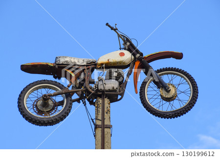 Motorcycle on the pedestal. A light motorbike on a pole, put up 130199612