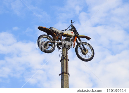 Motorcycle on the pedestal. A light motorbike on a pole, put up 130199614
