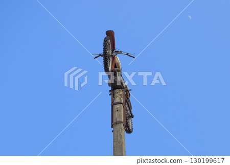 Motorcycle on the pedestal. A light motorbike on a pole, put up 130199617