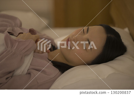 A woman sitting on a bed 130200837