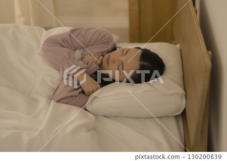 A woman sitting on a bed 130200839