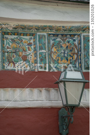 Ornate ceramic tilework featuring a winged seraphim face, floral motifs, and Orthodox Christian symbols in rich green, yellow, blue, and red tones 130201026