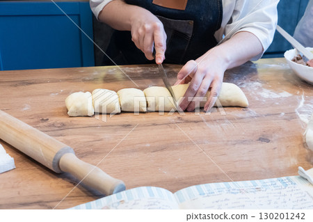 Woman preparing traditional cinnamon rolls in kitchen 130201242