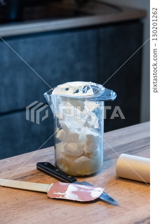 Fresh prepared cream from cheese mascarpone for cinnamon rolls surrounded by a silicone spatula and knife 130201262