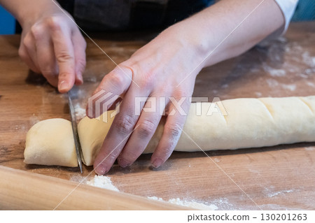 Woman preparing traditional cinnamon rolls in kitchen Woman preparing traditional cinnamon rolls in kitchen 130201263