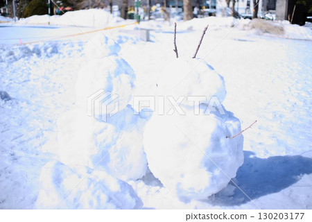 Two snowmen lined up in a snowy field 130203177