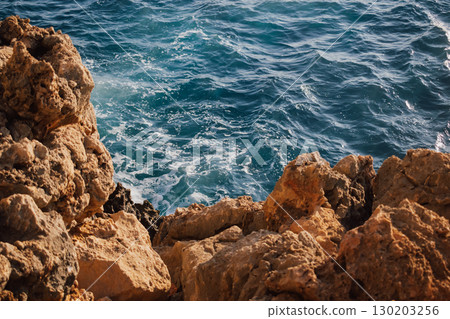 Sea and rocky Mediterranean beach, waves crashing against stones 130203256