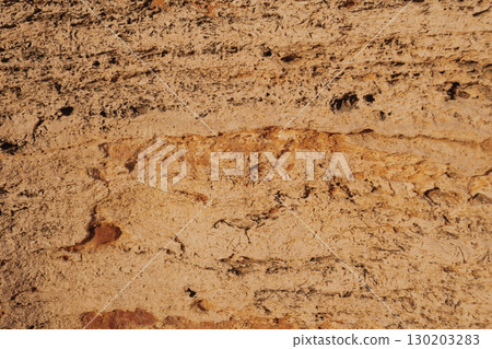Close-up texture of large ancient stone with abstract stripes and indentations 130203283