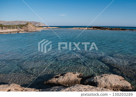 Rocky Sea Entrance at Elafonisi Beach with Clear Turquoise Water - Natural Coastal Texture of Crete Rocky Sea Entrance at Elafonisi Beach with Clear Turquoise Water - Natural Coastal Texture of Crete 130203289