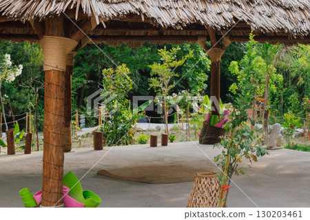 Gazebo with a thatched roof in the open air in a tropical garden for yoga. Veranda or terrace in Asian style for sports Gazebo with a thatched roof in the open air in a tropical garden for yoga. Veranda or terrace in Asian style for sports 130203461
