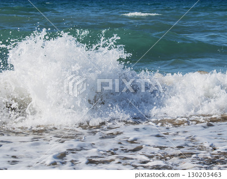 Powerful sea wave crashing on the shore, close-up of ocean spray and foam Powerful sea wave crashing on the shore, close-up of ocean spray and foam 130203463