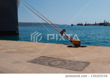 Mooring of a vessel in the port using mooring lines to a bollard on the quay Mooring of a vessel in the port using mooring lines to a bollard on the quay 130203538