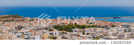 Panoramic view of the Greek city of Rethymno from a height on the island of Crete Greece. Residential buildings and the Aegean sea Panoramic view of the Greek city of Rethymno from a height on the island of Crete Greece. Residential buildings and the Aegean sea 130203589