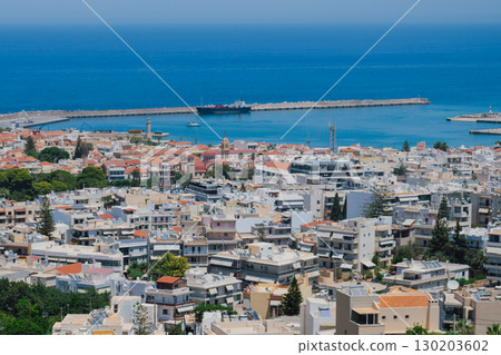 Panoramic view of the city of Rethymno in Crete and its port. View from the mountain to the residential buildings and the sea of the Greek pearl Panoramic view of the city of Rethymno in Crete and its port. View from the mountain to the residential buildings and the sea of the Greek pearl 130203602