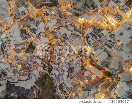 Santorini, town of Oia - drone view of the city illuminated by night lights from above 130203617