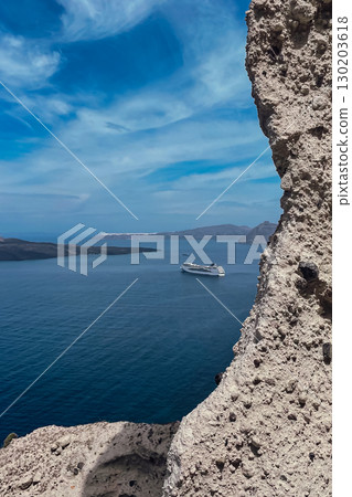 View of the sea and cruise ship on the Greek island of Santorini behind a cliff View of the sea and cruise ship on the Greek island of Santorini behind a cliff 130203618