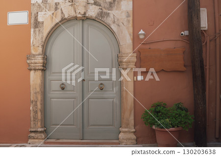 Mediterranean-style home entrance with massive wooden arched door in Venetian design Mediterranean-style home entrance with massive wooden arched door in Venetian design 130203638