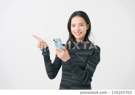 一個微笑的女人看著智能手機 130203703