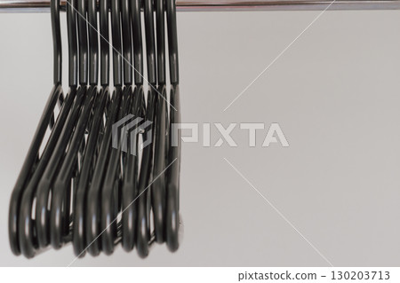 Plastic black hangers for adults in empty wardrobe 130203713