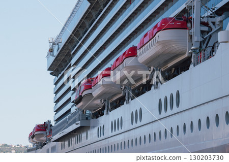 Lifeboats on the side of a cruise liner on a sunny day Lifeboats on the side of a cruise liner on a sunny day 130203730