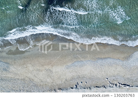 Overhead drone perspective of shoreline and sparkling foamy waves, ideal background Overhead drone perspective of shoreline and sparkling foamy waves, ideal background 130203763