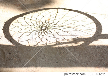 The round shadow of the playground equipment in the park reflected on the ground 130204294