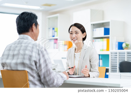 一位中年女商人向一位老人推銷產品 一位中年女商人向一位老人推銷產品 130205004