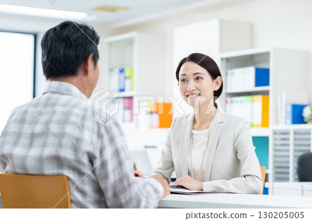 一位中年女商人向一位老人推銷產品 130205005