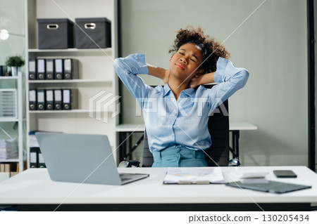 Overworked young businesswoman office worker suffering from neck pain after had a long day. office syndrome concept 130205434