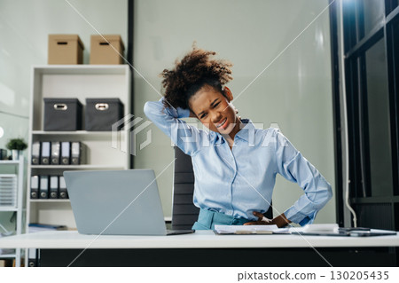Overworked young businesswoman office worker suffering from neck pain after had a long day. office syndrome concept 130205435