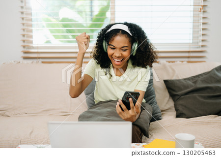 Young woman using a tablet in a cozy home, capturing creativity, relaxation, and digital connection Young woman using a tablet in a cozy home, capturing creativity, relaxation, and digital connection 130205463