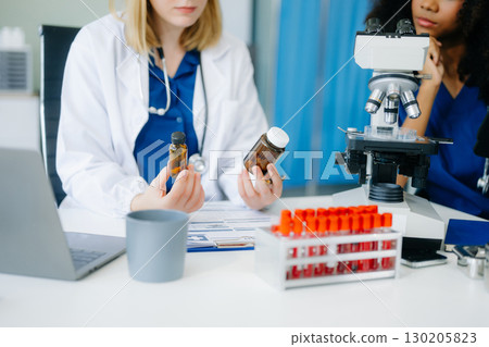 Modern Medical Research Laboratory Portrait of Two African American Scientists Working, Using Digital Tablet Modern Medical Research Laboratory Portrait of Two African American Scientists Working, Using Digital Tablet 130205823