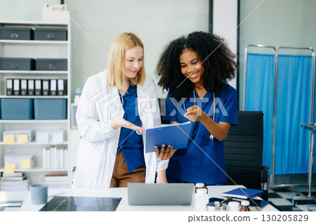 Doctors and nurses using laptops and clipboards, showcasing teamwork, modern healthcare. 130205829
