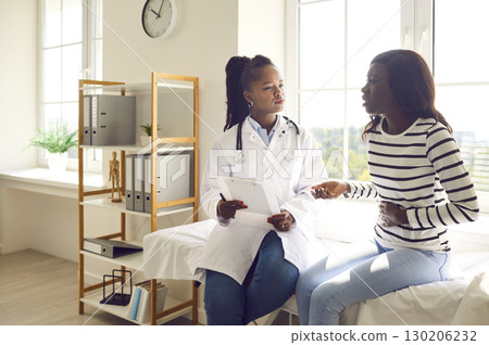 Sick woman with abdomen pain visiting her female therapist doctor in medical clinic. 130206232