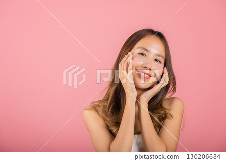 Femininity. Asian beautiful young woman smiling mask cosmetic patches gel under the eyes, Portrait female touching clean skin medical hydrogel eye patch on face, isolated on pink background, skincare 130206684