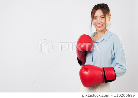 Happy Boxing Asian young woman in red glove shows strength and red boxing spirit. Confident business lady smiles with power, ready to fight. isolated studio white background Happy Boxing Asian young woman in red glove shows strength and red boxing spirit. Confident business lady smiles with power, ready to fight. isolated studio white background 130206689