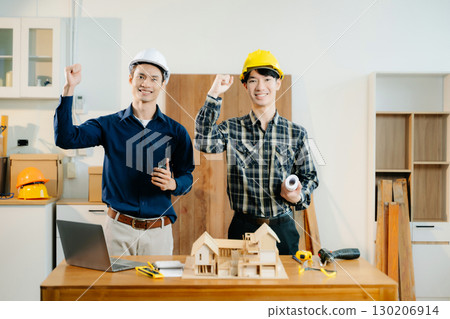 Architects and engineers collaborate on a building model, designing, planning, and measuring with teamwork, 130206914
