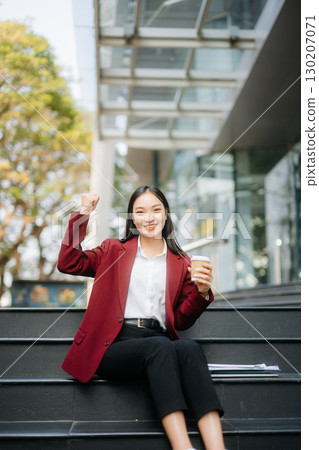 Confident Asian woman with a smile standing holding notepad and tablet at out side office. 130207071