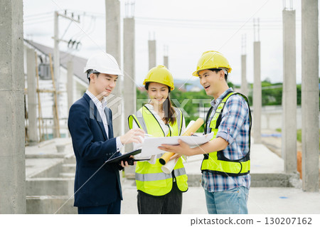 Contractor and architect looking at plan, tablet, laptop and talking about working on big project. Contractor and architect looking at plan, tablet, laptop and talking about working on big project. 130207162