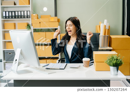 Young business owner woman prepare parcel box and standing check online orders for deliver to customer 130207264