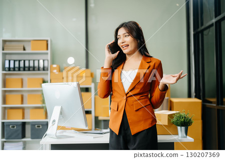 Woman Entrepreneur: SME Business mastering e-commerce with tablet, laptop, packaging, Woman Entrepreneur: SME Business mastering e-commerce with tablet, laptop, packaging, 130207369