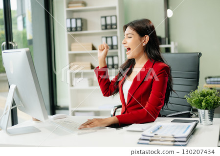 Asian woman using laptop and tablet while sitting at her working place 130207434